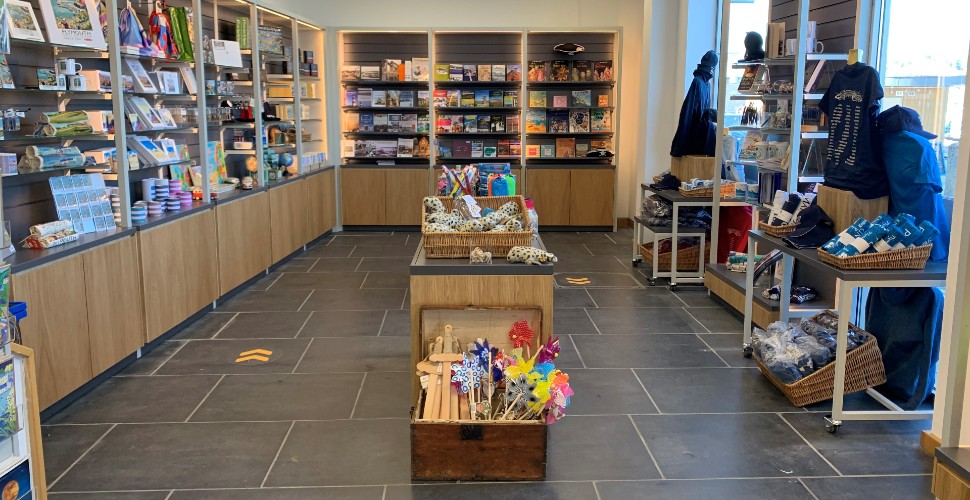 The interior of the Tourist Information Centre shop, with shelving around the outside displaying gifts and souvenirs